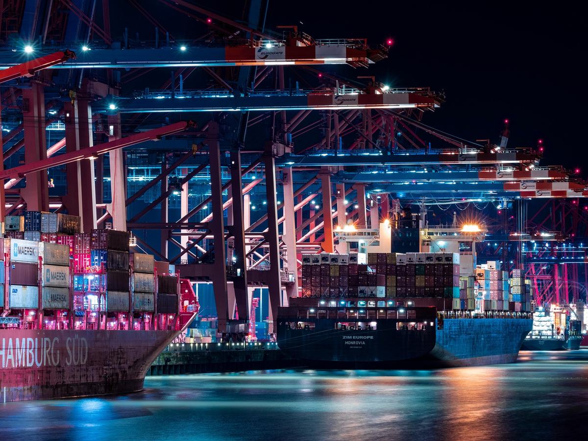 Container ships and cranes at a global shipping port at night
