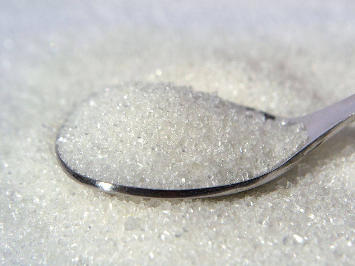Refined white sugar on a spoon