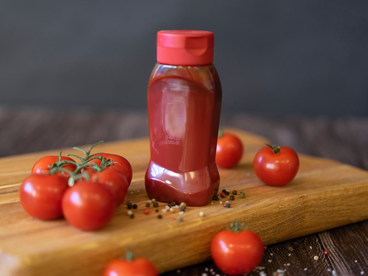 Tomato paste and ketchup bottle with fresh tomatoes